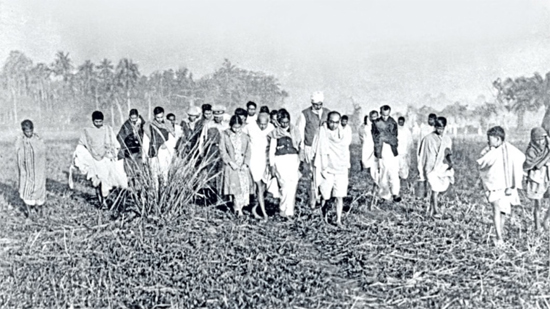 Mahatma Gandhi on his peace mission, walking through a paddy field during his visit to riot-affected areas in Noakhali, 1946.