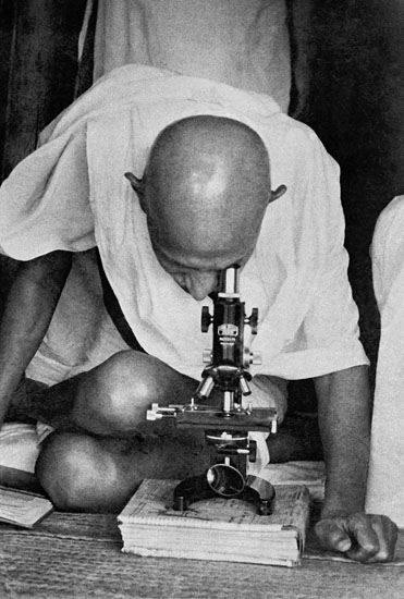 Mahatma Gandhi with the doctor studying the leprosy germs with microscope, Segaon, 1939