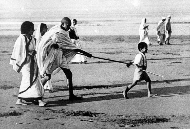 Gandhi Poking his grandson Kanaa during a walk at Juhu Beach (Bombay), 1937
