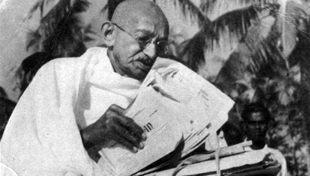 Mahatma Gandhi reading newspapers
